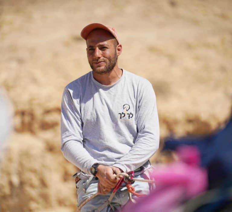 עקיבא עם כובע וציוד סנפלינג במדבר
